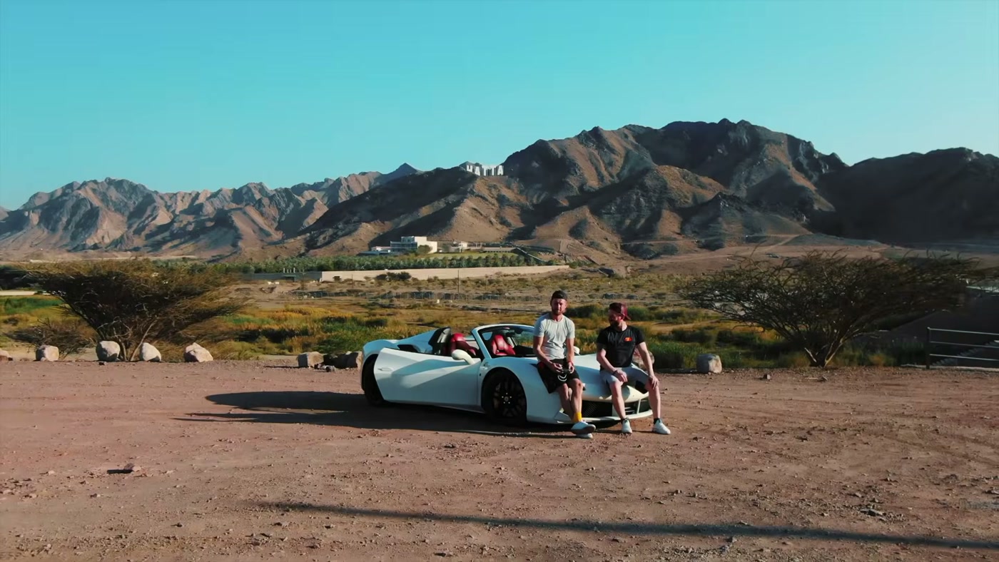 Marcin und Alex auf einem weißen Ferrari vor den Bergen bei Dubai