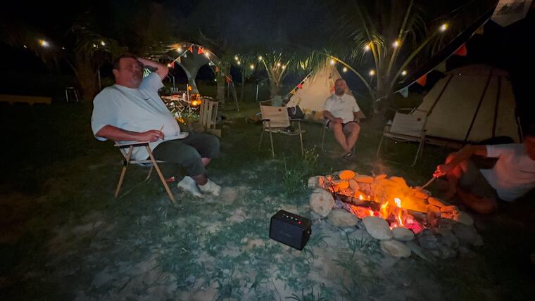 Abends am Lagerfeuer unter Lichterketten